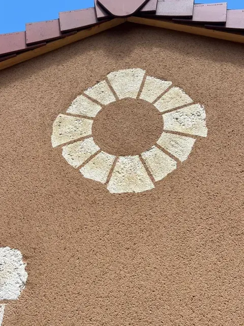 Détail d’une rosace façonnée dans l’enduit décoratif