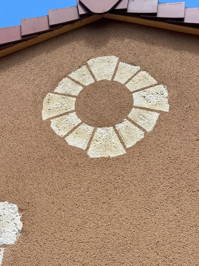 Détail d’une rosace façonnée dans l’enduit décoratif